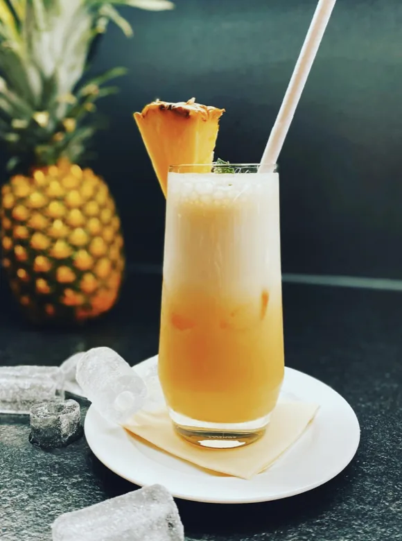 Ananas-Shake im Glas mit Eis und frischer Ananas